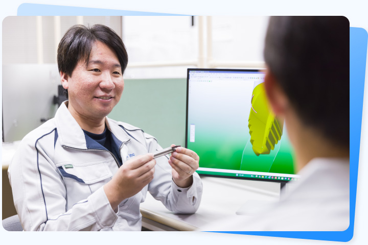 工具と3Dモデルを確認しながら加工方法を相談する社員