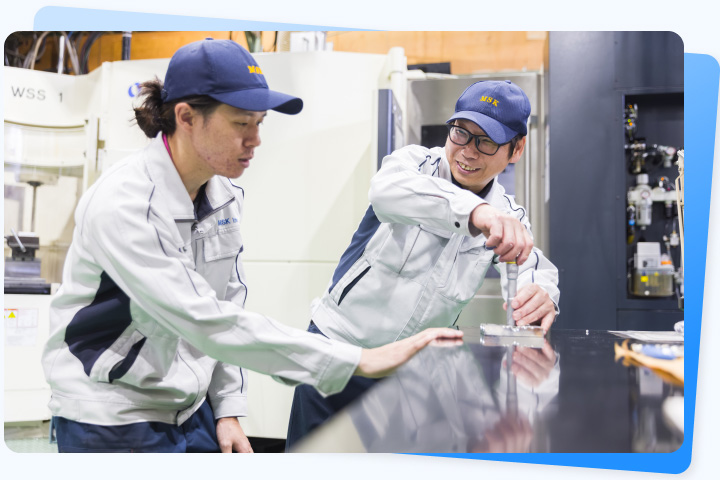 製造現場で加工について相談する社員
