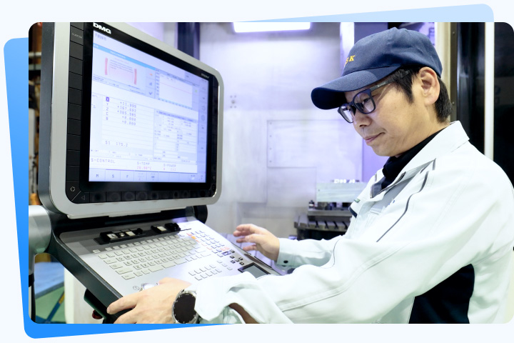 加工機の操作画面を確認する社員